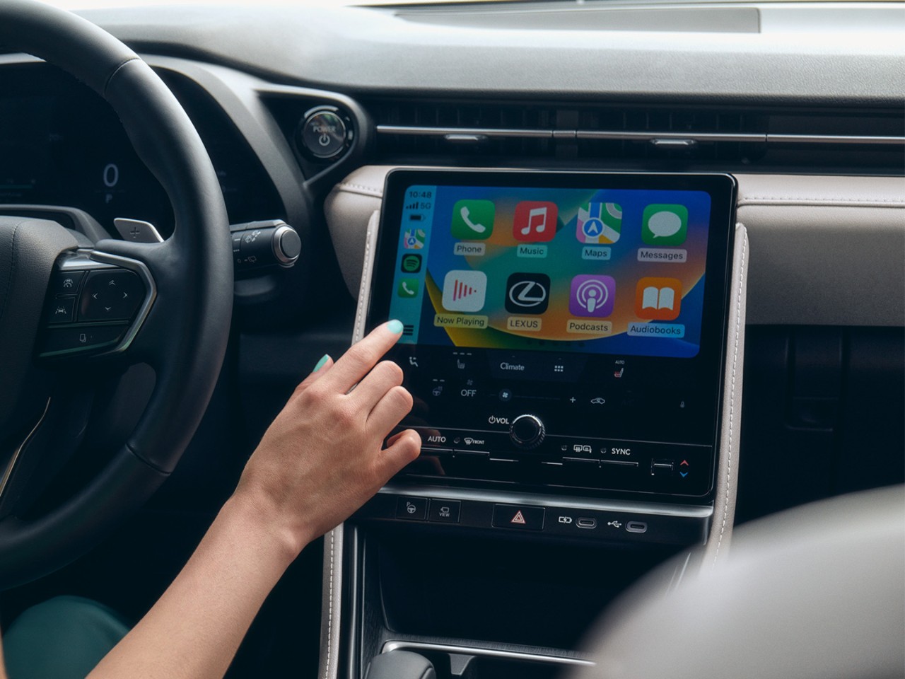 A person interacting with a Lexus multimedia touchscreen